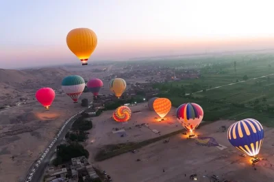 Experience luxor’s sunrise from a hot air balloon. see west bank temples, green fields, and local life. includes transfers, boat ride, and morning tea.