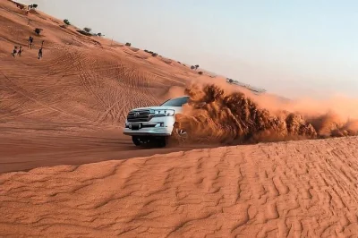 Découvrez le désert rouge de lahbab à dubaï avec quad, sandboard et balade à dos de chameau. transfert hôtel, dîner bbq et spectacle live inclus.