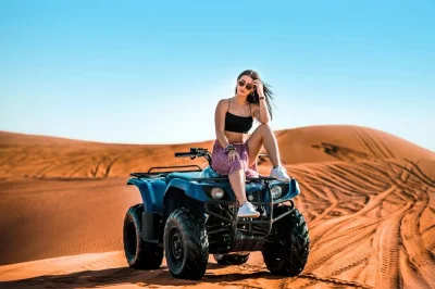 Découvrez les dunes rouges de dubai avec dune bashing, quad, balade à dos de chameau et dîner bbq. transfert hôtel inclus et spectacle vivant pour une soirée complète dans le désert.