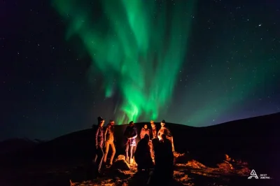Chase the northern lights from tromsø with a small group, private camp locations, expert guide, and warm drinks by the fire. includes minibus pickup and photos.