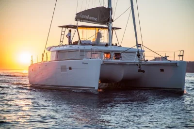 Feel the aegean breeze on a santorini catamaran cruise with thirassia swim stop, volcanic hot springs, and fresh dinner onboard. includes pickup and open bar.