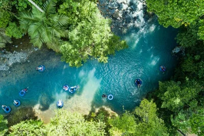 Viva a emoção do tubing no rio celeste, deslize pela floresta vibrante e aproveite lanches à beira do rio. tudo incluso: equipamento, toalhas e guia local para um passeio tranquilo.