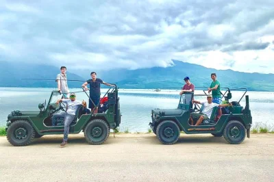 Feel the breeze in a restored u.s. army jeep from hue to hoi an, swim at nhi ho waterfalls, lunch on lang co beach, and cross hai van pass with pickup included.