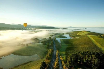 Watch sunrise over yarra valley vineyards from a hot air balloon, help set up and pack down, and enjoy breakfast at balgownie estate. includes pickup and flight photos.