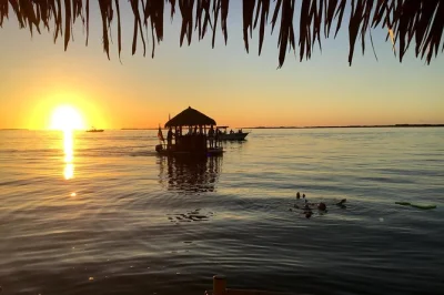 Feel the florida keys breeze on a floating tiki bar cruise in key largo, with music, swimming stops, and sunset views. includes drinks cooler and local guide.
