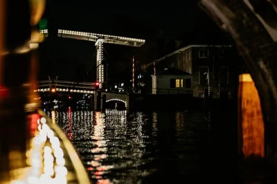 Disfruta de un paseo nocturno por los canales iluminados de Ámsterdam, saborea vino local o cerveza artesanal y prueba quesos holandeses en un grupo pequeño con un guía amable. incluye bebidas y ta