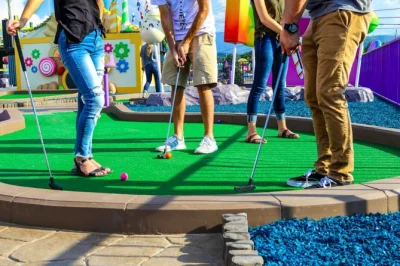 Erlebe mini golf im candy-style im crave golf club in pigeon forge. spiele drinnen und auf der dachterrasse, besuche den süßigkeitenladen und genieße familienzeit mit bester lage.