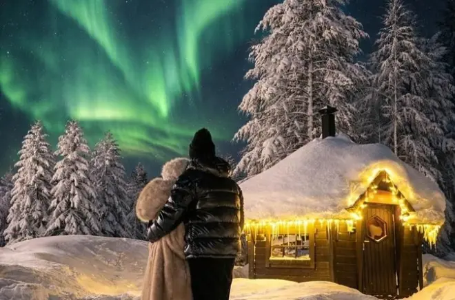 Aurora boreale e stelle a Levi con vista sul lago ghiacciato