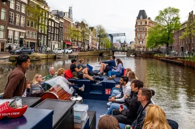 Scopri amsterdam dai suoi canali a bordo di una piccola barca elettrica, sorseggiando due drink inclusi e ascoltando storie dal vivo sulla magere brug e altri luoghi iconici.