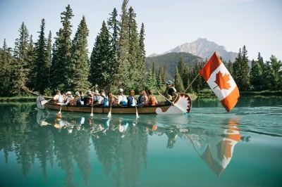 Erlebe die ruhe des bow river in banff bei einer geführten kanutour im großkanu. gemeinsames paddeln, spannende geschichten und kinderleichter einstieg – schwimmwesten und paddel inklusive.
