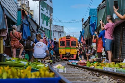 Erlebe den nervenkitzel, wenn der zug am maeklong railway market direkt an dir vorbeifährt, und gleite danach mit dem longtail-boot über den damnoen saduak floating market. inklusive abholung und gu