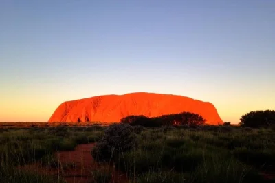 Veja uluru mudar de cor no pôr do sol, deguste espumante e petiscos em grupo pequeno com transfer do hotel. guia local incluso.