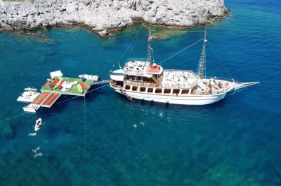 Erlebe eine traditionelle gulet-bootstour ab rhodos, schwimme in der anthony quinn bay, spiele auf fun islands wasser-spielgeräten und genieße ein griechisches mittagessen mit lokalem wein.