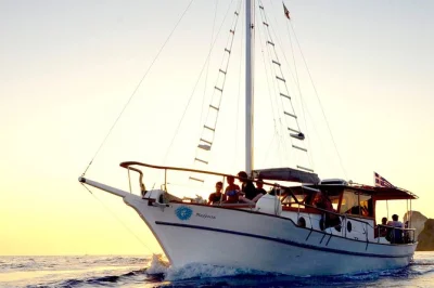 Set sail from oia on a santorini caldera sunset cruise, swim at thirassia, enjoy a greek meal on board, and watch the sky change from the deck. includes hotel pickup.