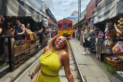 Watch trains pass through maeklong market, ride a private boat at damnoen saduak floating market, and taste local treats. includes hotel pickup and guide.