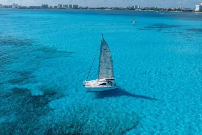 Siente la brisa en catamarán a isla mujeres, haz snorkel en el arrecife de bahía mujeres, relájate en playa norte y disfruta buffet y barra libre con traslado incluido.
