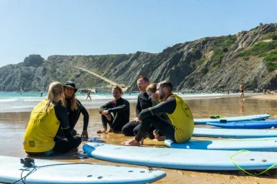 Siente la brisa atlántica con una clase de surf para principiantes en la costa salvaje del oeste de portugal. incluye neopreno, tabla y traslado a las playas de arrifana o amoreira.