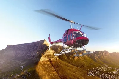 Erlebe cape towns küste, den tafelberg und die city aus der luft bei einem hubschrauberflug mit live-kommentar, inklusive glas sekt und rücktransfer.