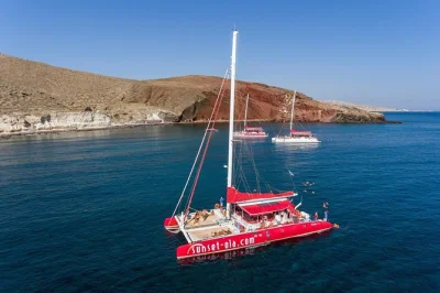 Feel the sea breeze on a santorini catamaran cruise with swimming at red & white beaches, a volcanic hot springs stop, bbq lunch, drinks & hotel transfer.