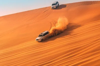 Feel the rush of dune bashing near doha, sip tea with camels, try sandboarding, and see the inland sea. includes pickup, local guide, and drinks.