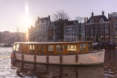 Découvrez amsterdam depuis ses canaux unesco en sirotant des boissons locales et grignotant des snacks hollandais, avec vue sur la maison d’anne frank, le pont maigre et plus, guidé en direct—co