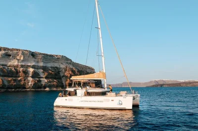 Parti dal porto di vlychada a santorini per una crociera al tramonto in catamarano, nuota a red beach, rilassati alle sorgenti termali e gusta una cena greca con bbq e bevande incluse.