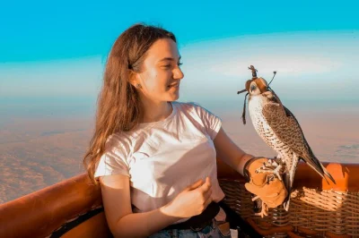 Vivi l’alba nel deserto di dubai a bordo di una mongolfiera, ammira un falco che vola accanto a te e gusta un caffè nell’aria fresca del mattino. include transfer e guida.