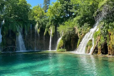 Let the sound of waterfalls guide you through plitvice lakes on a day trip from zadar, with tickets, boat and train ride, plus pickup included for a relaxed journey.