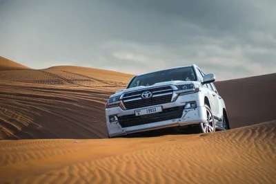 Erlebe dubais rote dünen hautnah mit dune bashing, sandboarding, kamelreiten und einem beduinen-bbq. inklusive hoteltransfer und abendlichen live-shows.