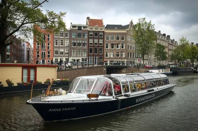 Siente el encanto de los canales de Ámsterdam en un crucero guiado de 1 hora con historias en vivo, vistas como la casa de ana frank y opción de bebidas. baño a bordo incluido.