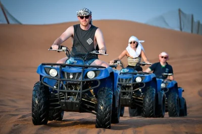Erlebe dubais rote sanddünen hautnah mit quad fahren, dune bashing und kamelritt – inklusive hoteltransfer, englischsprachigem guide und wasserflasche.