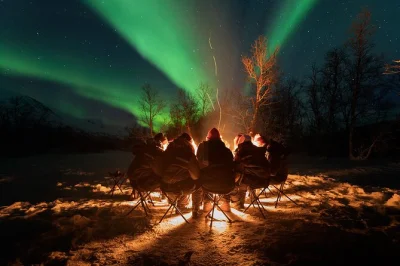Chase the northern lights from tromsø in a cozy small group, warm up by a campfire, get expert photo tips, and receive pro photos—includes pickup & thermal suit.