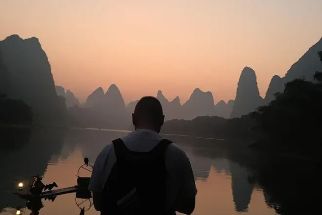 Lever de soleil sur la rivière Li à Guilin avec un pêcheur local