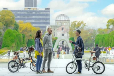 Explore hiroshima de bicicleta elétrica com guia local. visite o parque memorial da paz, pontos históricos da bomba e ouça relatos da cidade. inclui aluguel de e-bike.