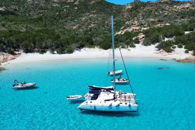 Set sail from cannigione to the maddalena islands on a catamaran, swim in turquoise bays, see the pink beach, and enjoy a sardinian lunch with drinks included.