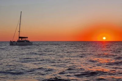 Feel the aegean breeze on a santorini catamaran cruise, with stops at red beach and white beach, swimming near volcanic springs, bbq lunch, and hotel transfers.