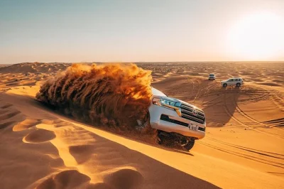 Erlebe den nervenkitzel der lahbab-wüste in dubai mit dune bashing, sandboarding und kamelritt. inklusive hoteltransfer, wasser und lokalem guide für einen entspannten morgen.