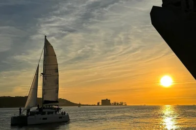Feel the shift from day to night on a tagus river catamaran cruise in lisbon, with portuguese wine, city lights, and local stories. includes skipper & all fees.