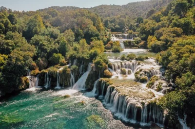 Feel the mist at krka’s waterfalls, cruise to skradin by boat, swim where river meets sea, and wander a dalmatian town—includes guide, transport & free time.