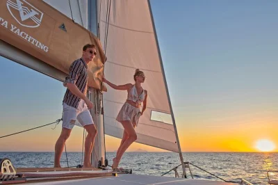 Segeln bei sonnenuntergang an santorinis roten & weißen stränden, vulkanbad, griechisches bbq und getränke auf einer kleinen katamaran-tour mit hoteltransfer.