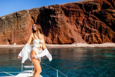 Feel the aegean breeze on a santorini catamaran cruise with swim stops at red beach, thirasia, and volcanic hot springs. includes bbq lunch, open bar, and pickup.