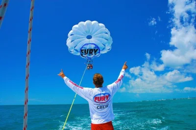 Spüre den wind beim parasailing über dem türkisblauen wasser von key west, entdecke delfine unter dir und erfrische dich mit einem sprung ins meer. sanfter start und digitale fotos zum kauf inklusi