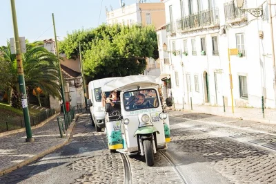 Feel the rhythm of lisbon from a private tuk tuk. explore alfama, belém tower, and secret viewpoints with a local guide. includes hotel pickup and blankets.