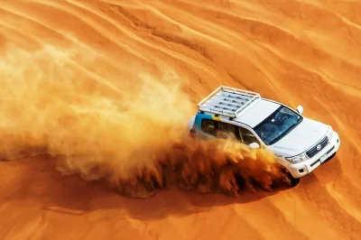 Abu dhabi wüstensafari erleben: 4x4 dünenfahrt, kamelritt, sandboarding, bbq-abendessen und bauchtanz. jetzt dein abendabenteuer buchen.