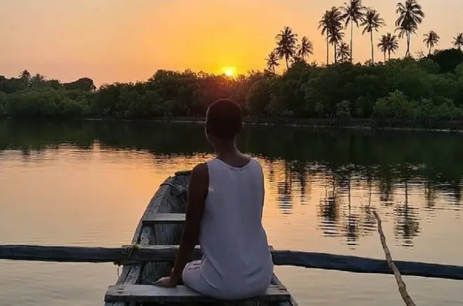 Sonnenuntergangskanu an der Kongo-Mündung mit traditionellem Paddeln