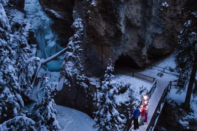Descubre johnston canyon en banff de noche con una caminata guiada sobre hielo. incluye linterna frontal, chocolate caliente, galletas de arce y traslado desde banff. reserva ya.